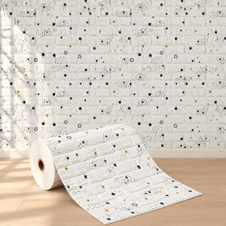 Stars foam brick, white brick printed with small stars, being pressed onto a wall