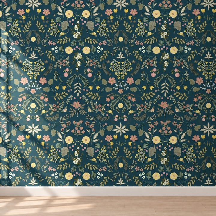 Teal garden wallpaper behind a wooden desk and lamp