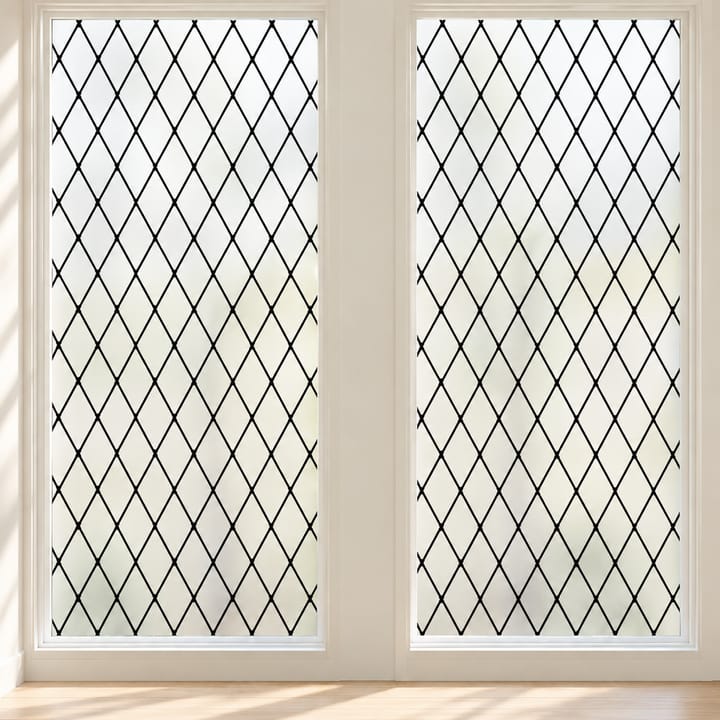 Two tall windows covered in black lattice frosted film behind a pendant lamp