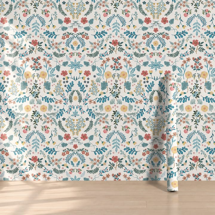 Folk bloom wallpaper with teal and orange folk flowers and a roll against the wall