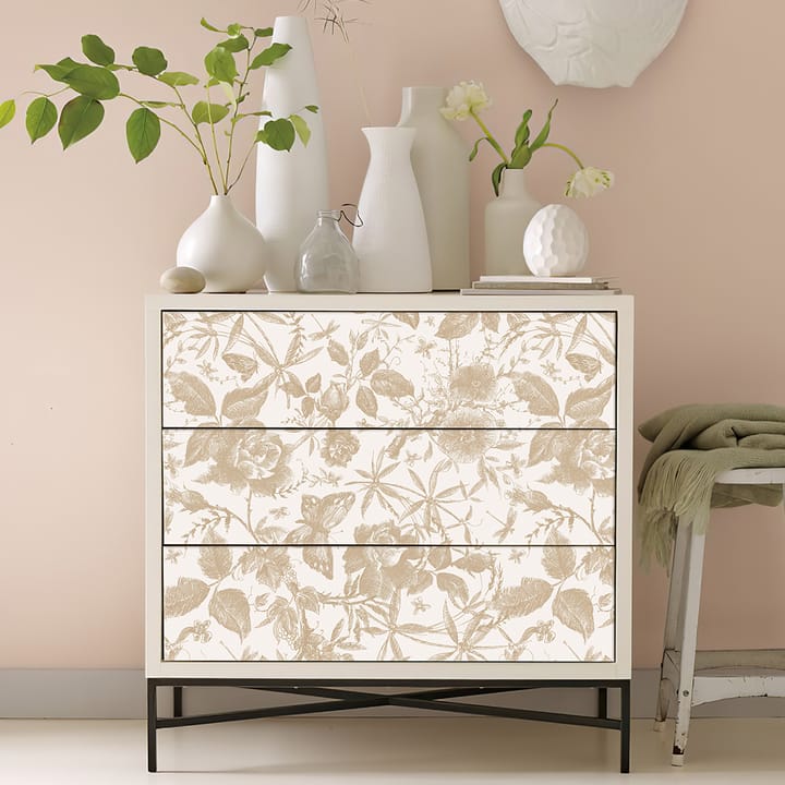 White dresser with drawer fronts covered in champagne rose wallpaper