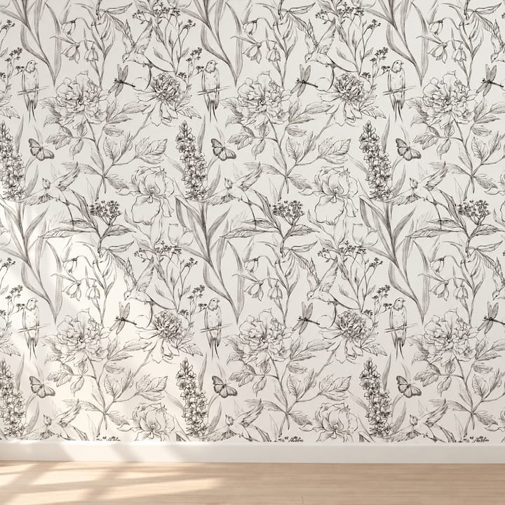 Lily and dragonfly line floral wallpaper behind a lamp on a wooden table