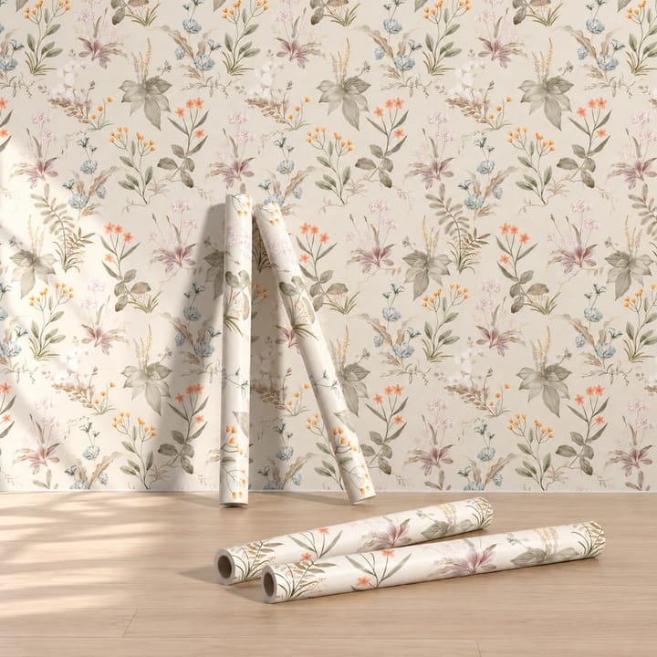 Rolls of Cream meadow wallpaper leaning against a papered wall